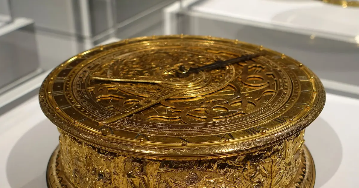 A German brass astronomical clock with a frieze of Orpheus and an astrolabe face with rotating plates.